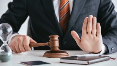Man holding gavel with hand up regarding information on what injunctive relief is.
