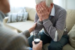 Senior man holding his face regarding the nursing home class action lawsuit filed after 31 seniors die