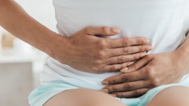 Woman in pain holding her abdominal area regarding the AMS transvaginal mesh settlement