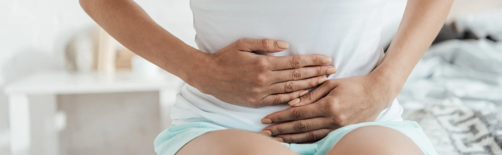 Woman in pain holding her abdominal area regarding the AMS transvaginal mesh settlement - transvaginal mesh class action lawsuit