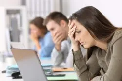 Workers looking upset over an email regarding the Steve Nash Fitness World class action lawsuit alleging unfair termination