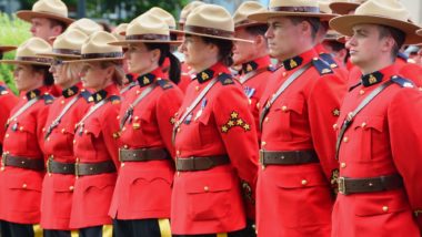 RCMP standing in a row regarding the RCMP class action lawsuit settlement opening for claims