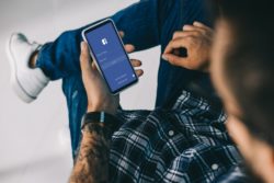 Man using facebook regarding Facebook's privacy settlement to end Canadian probe 