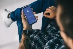Man using facebook regarding Facebook's privacy settlement to end Canadian probe