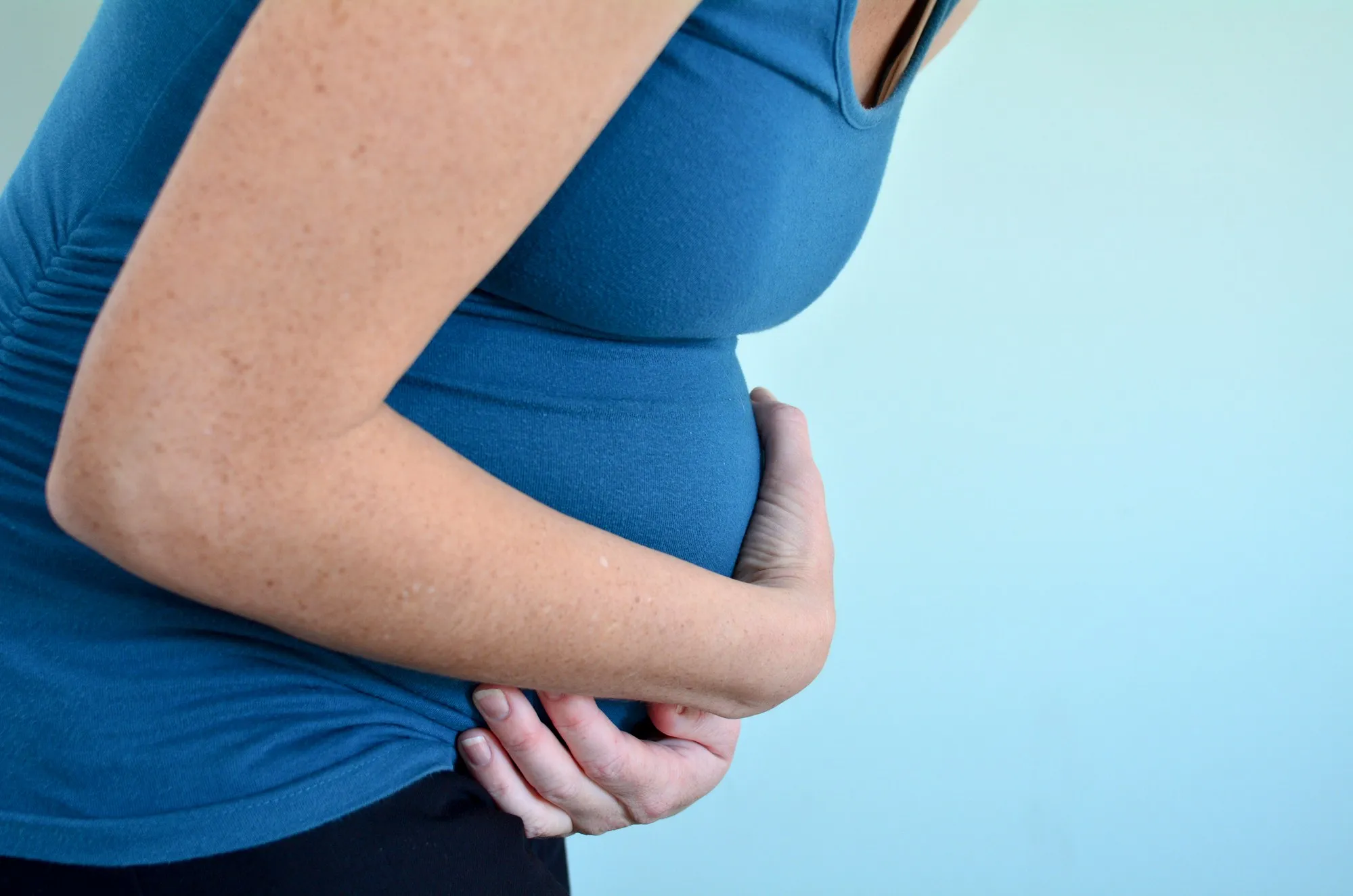 Pregnant woman holding belly regarding the compensation settlement approved for those negatively impacted by morning sickness drug thalidomide