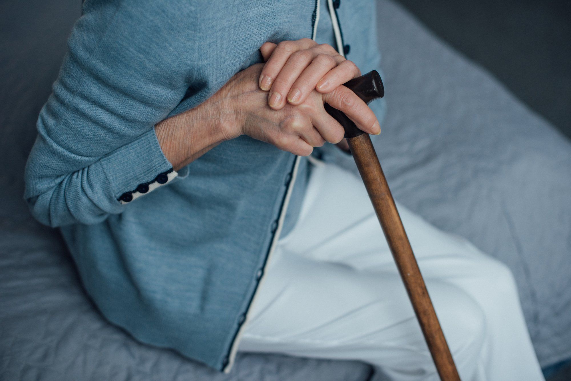 Senior woman sitting down on bed regarding the Long-Term Care Homes class action lawsuit filed against a group that operates 25 facilities