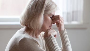 Woman touching her face in pain regarding the Elmiron class action lawsuit alleging the drug causes vision loss