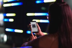 Woman using Uber app amid Uber class action 