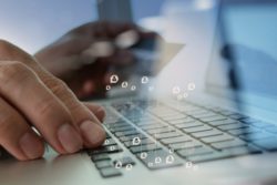 fingers on keyboard with social icons regarding the Capital One data breach class actin lawsuit 