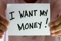 person holding sign saying i want my money regarding the Sixties Scoop survivors' settlement checks being delayed