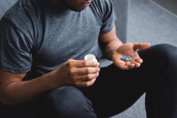 Man looking at pills regarding the Grand Prairie opioid class action lawsuit filed
