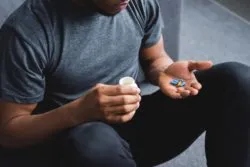 Man looking at pills regarding the Grand Prairie opioid class action lawsuit filed