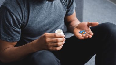 Man looking at pills regarding the Grand Prairie opioid class action lawsuit filed