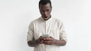 Man looking shocked and upset at phone regarding the Fitness Depot data breach