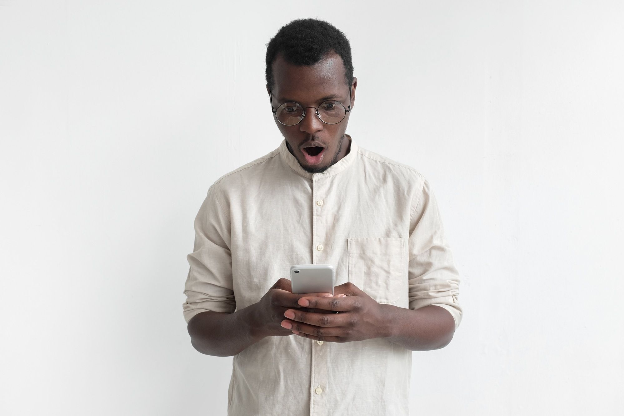 Man looking shocked and upset at phone regarding the Fitness Depot data breach 