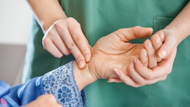 nurse checking person's pulse regarding the Orchard Villa class action lawsuit filed Amid COVID-19 deaths
