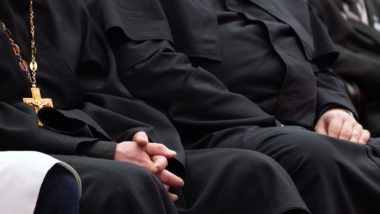people sitting in catholic mass in black robes regarding the five members of the Clerics of St. Viator being arrested for sexual abuse allegations