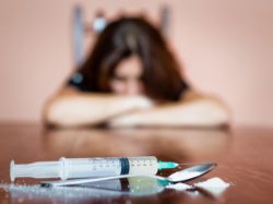 Woman arms on table with drugs regarding the claims of relapse in the Methadose class action lawsuit 