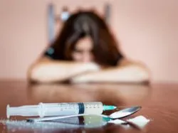 Woman arms on table with drugs regarding the claims of relapse in the Methadose class action lawsuit 