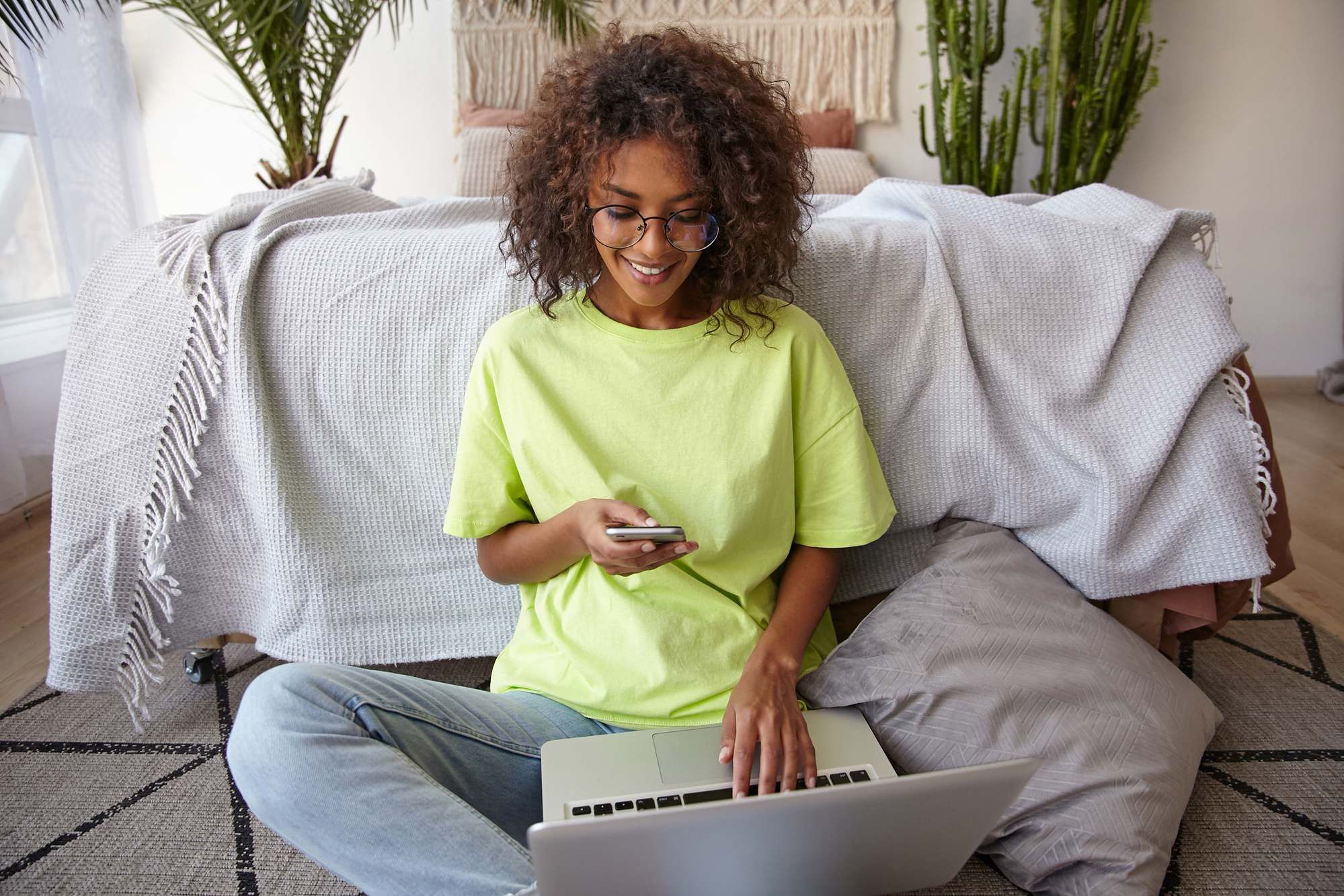Woman sitting on floor using the internet regarding Telus lawsuit against Shaw Communications over Fibre+ internet service