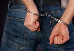 handcuffed man after coughing on someone during COVID