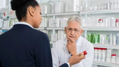 Woman speaking with pharmacist regarding the pharmacy privacy breach class action lawsuit filed