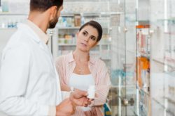 Woman listening to pharmacist regarding the pharmacy privacy breach class action lawsuit filed 