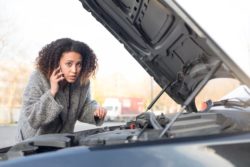 woman with car hood up regarding the Denso fuel defect class action lawsuit in Canada