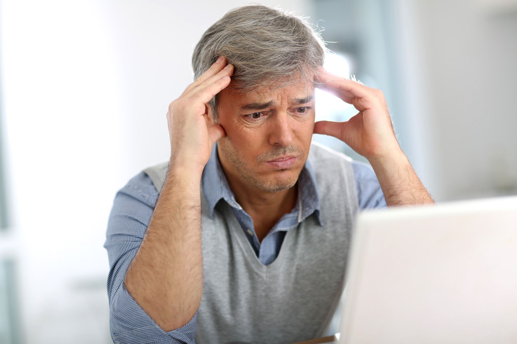 Upset man reading email regarding nformation on how termination can affect long-term disability benefits 