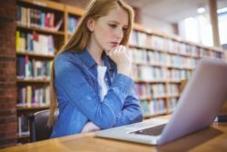 university student looking at computer in university library