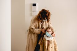 Woman putting mask on girl regarding the mandatory mask lawsuit 