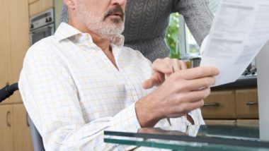 Woman looking a letter with man regarding information on what to do if you're terminate on long-term disability