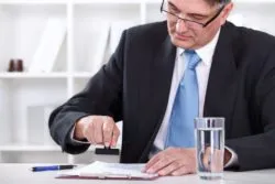 Man stamping documents regarding the certification of the First Nation Band class action lawsuit 