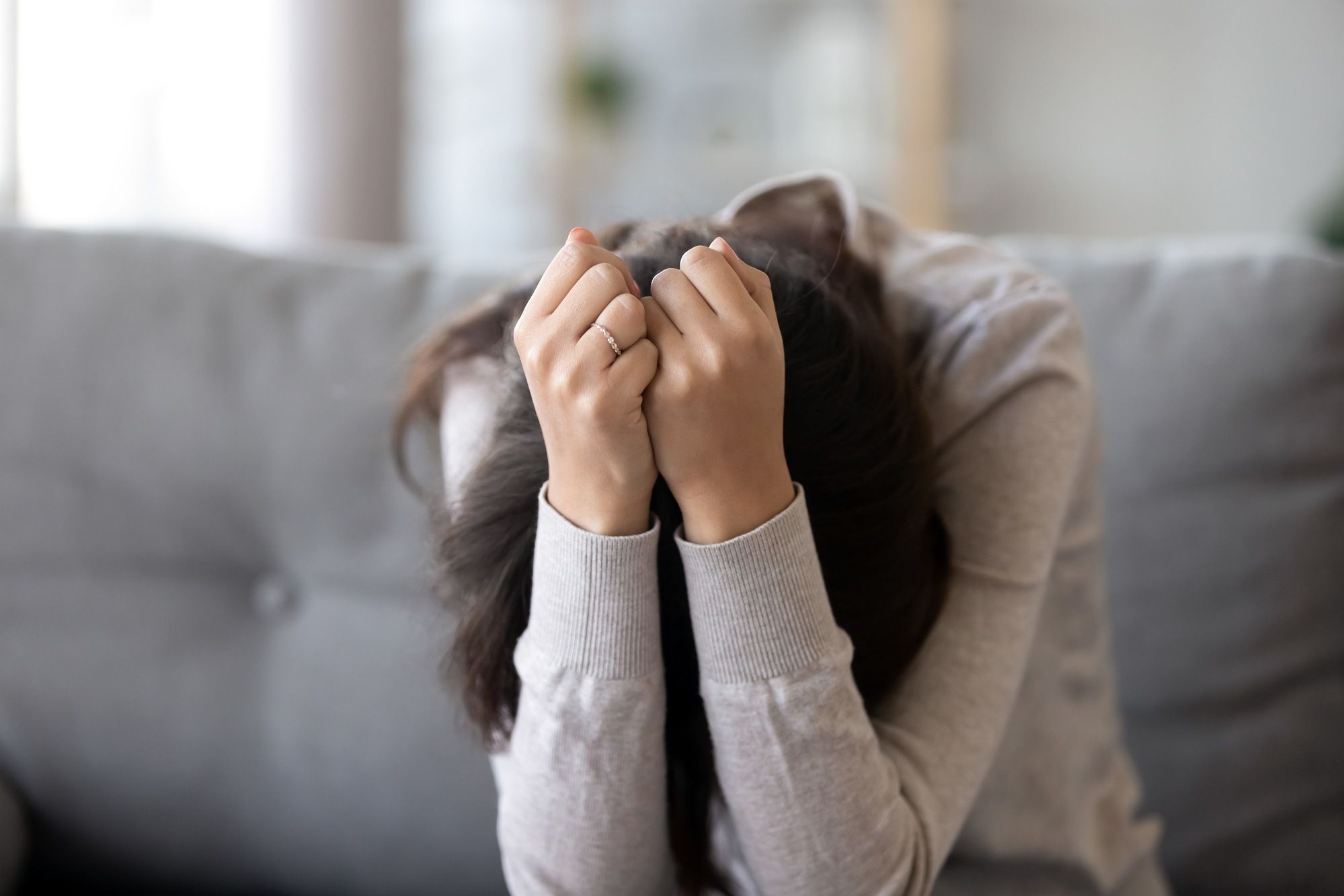 Distressed woman with head in arms regarding the missing indigenous women class action lawsuit seeking certification 