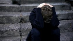 Sad boy with head in arms regarding the Catholic Church Appeals to The Supreme Court Over Sex Abuse Lawsuits