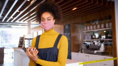 Business owner wearing mask regarding information on business interruption insurance