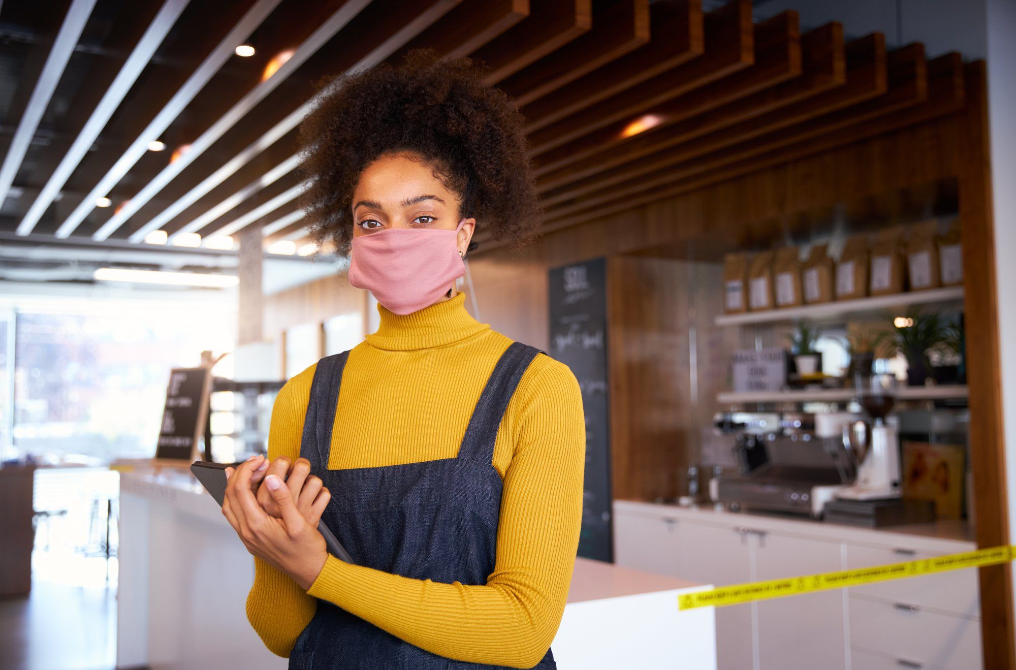 Business owner wearing mask regarding information on business interruption insurance 