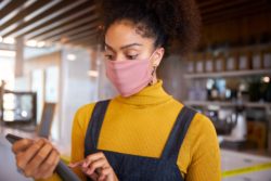 Coffee shop owner wearing mask regarding the Angelina's class action lawsuit filed over denied insurance coverage