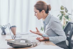 Upset lawyer on laptop regarding the indigenous lawyer's lawsuit against the firm representing Indian Day School Survivors Class