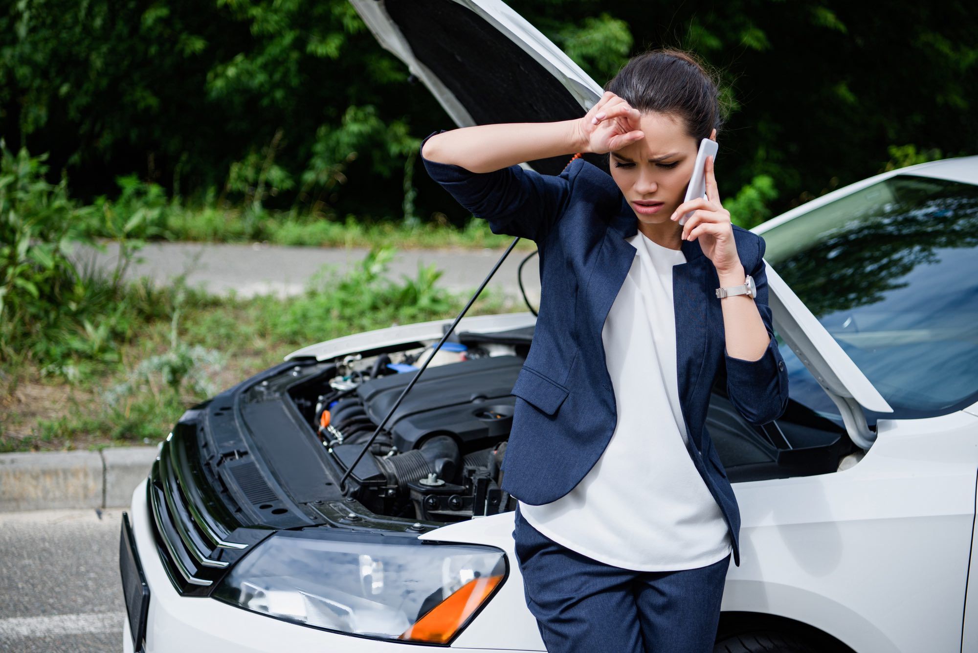 woman on phone with broken down car due to defective timing chain