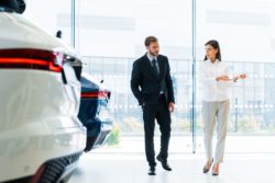 saleswoman selling cars wearing white 