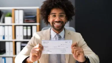 Man holding check regarding the Livingston Employee Overtime Class Action Settlement checks mailed