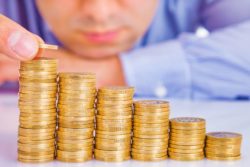 Person stacking coins regarding the TD Asset Management class action lawsuit filed 