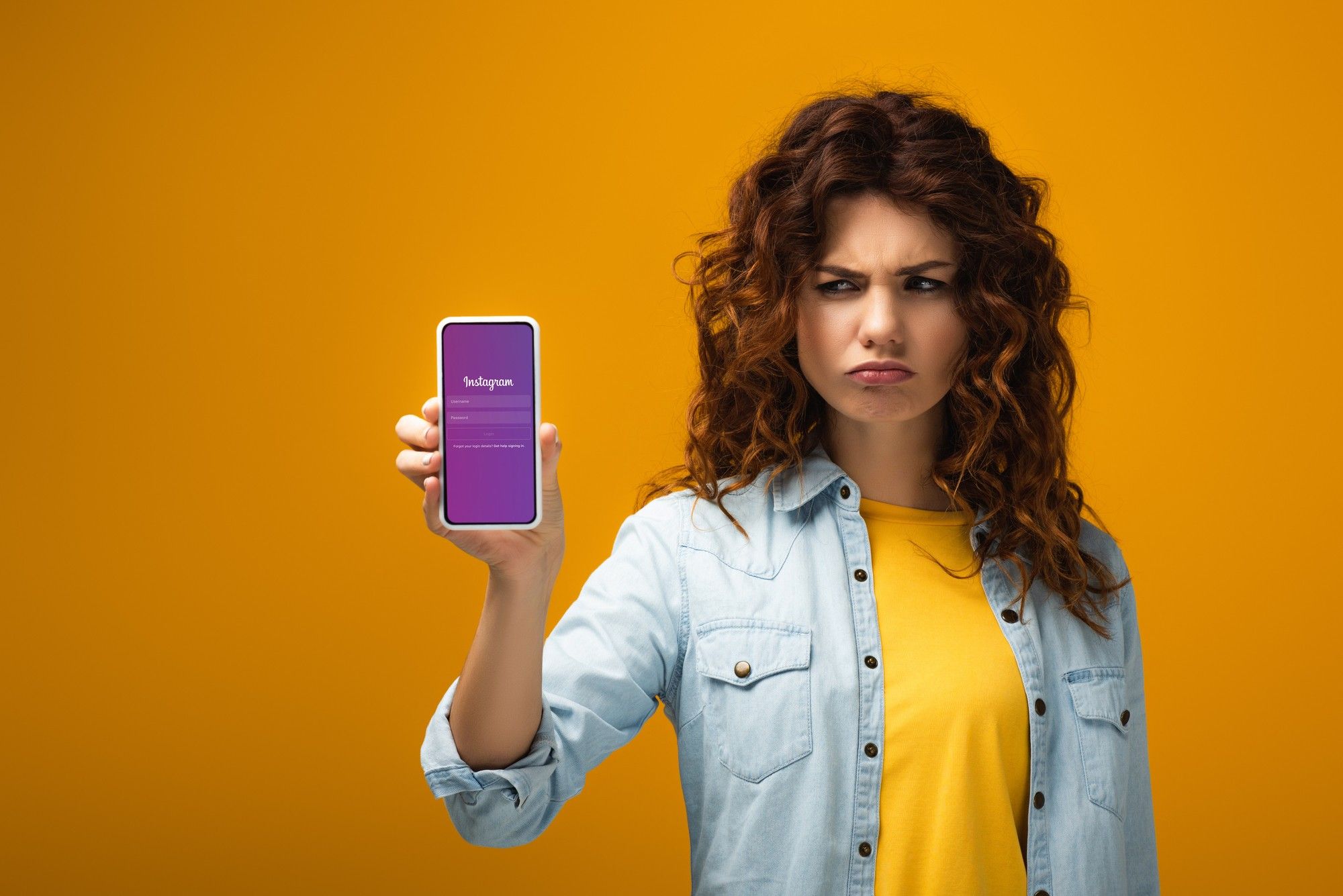 Upset woman holding Apple device regarding the Facebook privacvy breach class action lawsuit accessing Instagram camera