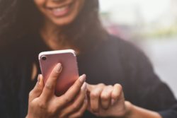 Woman using iphone regarding the lawsuit Apple filed against GEEP 