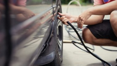 Person checking tire pressure regarding the FCA TPMS defect class action lawsuit
