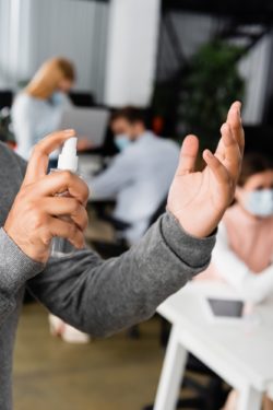spraying hand sanitizer