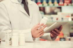 Pharmacist with pill bottle regarding the Purdue Pharma opioid class action lawsuit 