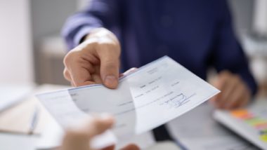 Person handing over cheque regarding the NSF fee class action lawsuit