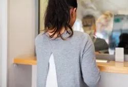 Woman at bank regarding the NSF fee class action lawsuit